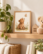 Watercolour teddy bear with paws resting down, looking up at a butterfly among daisies and soft foliage styled in a shelf display