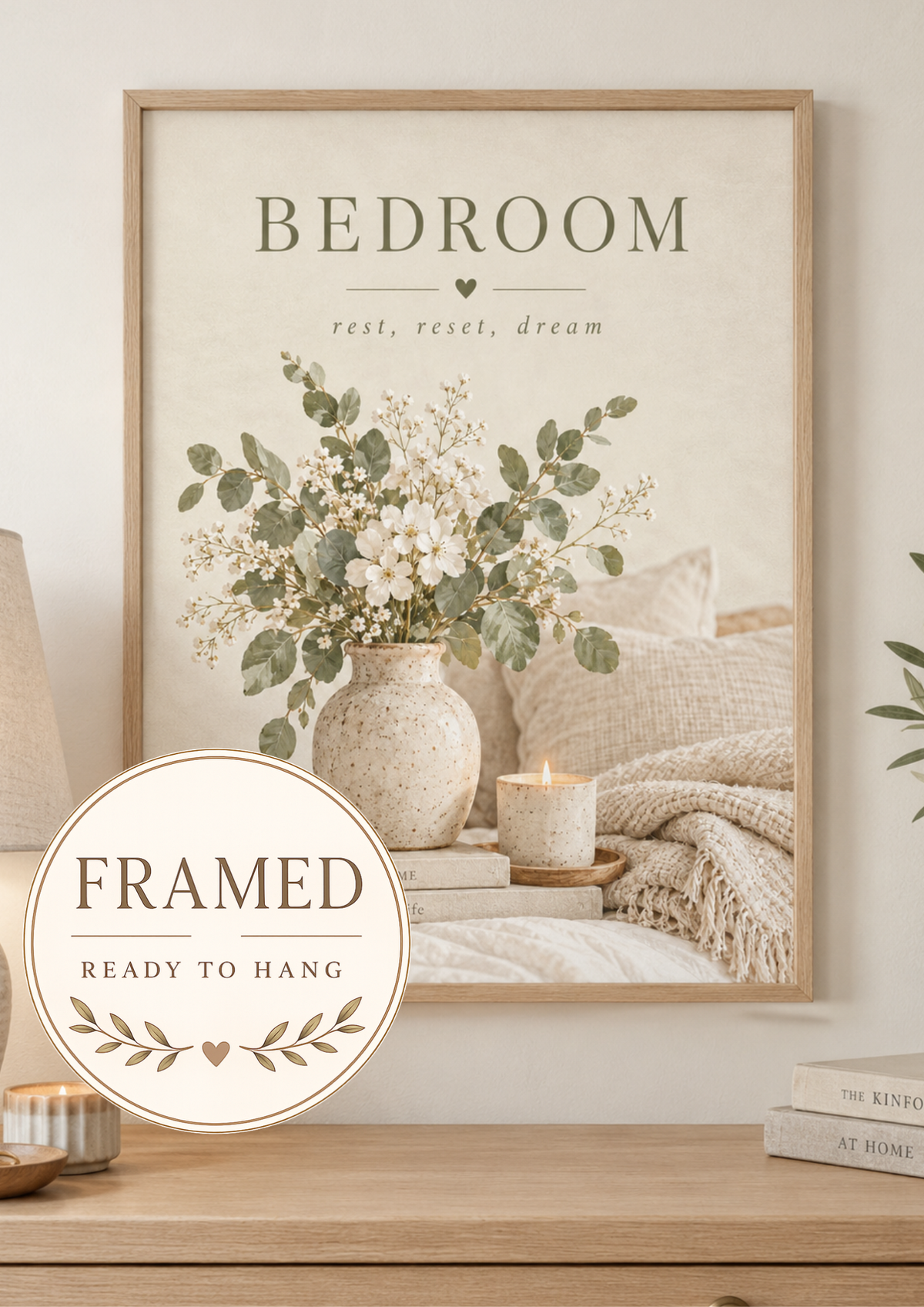 Bedroom rest reset dream quote with white flowers, sage foliage, ceramic vase, candle, books and soft neutral bedding; framed and ready to hang badge