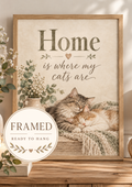 Home is where my cats are artwork with two sleeping cats, white flowers, sage foliage, candle, wooden heart and knitted blanket; framed and ready to hang badge