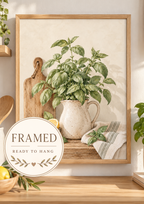 Watercolour basil plant in a speckled ceramic jug with lemons, wooden chopping board and striped kitchen cloth; framed and ready to hang badge