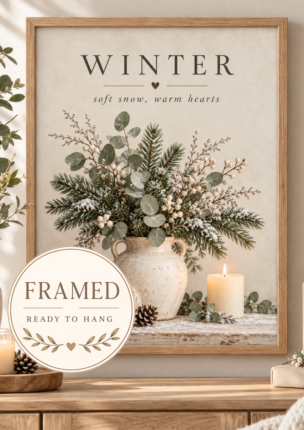 Winter soft snow, warm hearts artwork with snowy evergreens, eucalyptus, white berries, ceramic vase, knitted blanket, pine cones and candle; framed and ready to hang badge