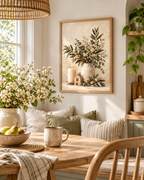 Neutral botanical artwork with white flowers, foliage, a cream vase, candle and wooden house styled in a dining corner