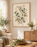 Delicate sage green eucalyptus, olive-toned foliage and ivory-white flowers on a warm neutral background styled in a living room