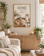 Home is where my cats are artwork with a cat sleeping in a woven basket and another sitting beside it, flowers, books, candle and knitted blankets styled in a living room