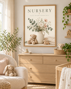 NURSERY little dreams bloom here artwork with cream and blush flowers, sage foliage, ceramic jug, teddy bear, wooden bunny and knitted blanket styled in a nursery chest of drawers area