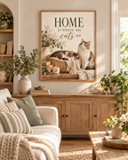 Home is where my cats are artwork with a cat sleeping in a woven basket and another sitting beside it, flowers, books, candle and knitted blankets styled in a sideboard