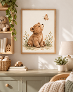 Watercolour teddy bear with paws resting down, looking up at a butterfly among daisies and soft foliage styled in a reading corner