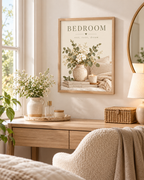 Bedroom rest reset dream quote with white flowers, sage foliage, ceramic vase, candle, books and soft neutral bedding styled in a dressing area