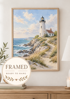 Painterly coastal landscape with white lighthouse and cottage, blue ocean waves, rocky shore, sandy path, wooden fence and coastal grasses; framed and ready to hang badge