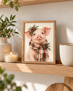 Christmas pink piglet illustration with tartan scarf, evergreen sprigs, red berries and pine cones on a warm cream background styled in a shelf