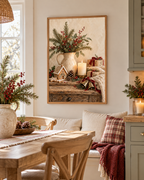 Rustic Christmas artwork with a gingerbread house, winter greenery, candle and wrapped gifts beside a dining table