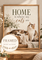 Home is where my cats are artwork with a cat sleeping in a woven basket and another sitting beside it, flowers, books, candle and knitted blankets; framed and ready to hang badge