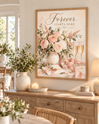 Forever Starts Here wedding artwork with blush and ivory roses, muted green foliage, champagne glasses, engagement ring, ribbons and wedding stationery styled in a dining room
