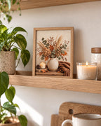 Autumn floral still life with dried hydrangeas, eucalyptus, copper leaves, rustic vase, candle, acorns and knitted throw styled in a shelf