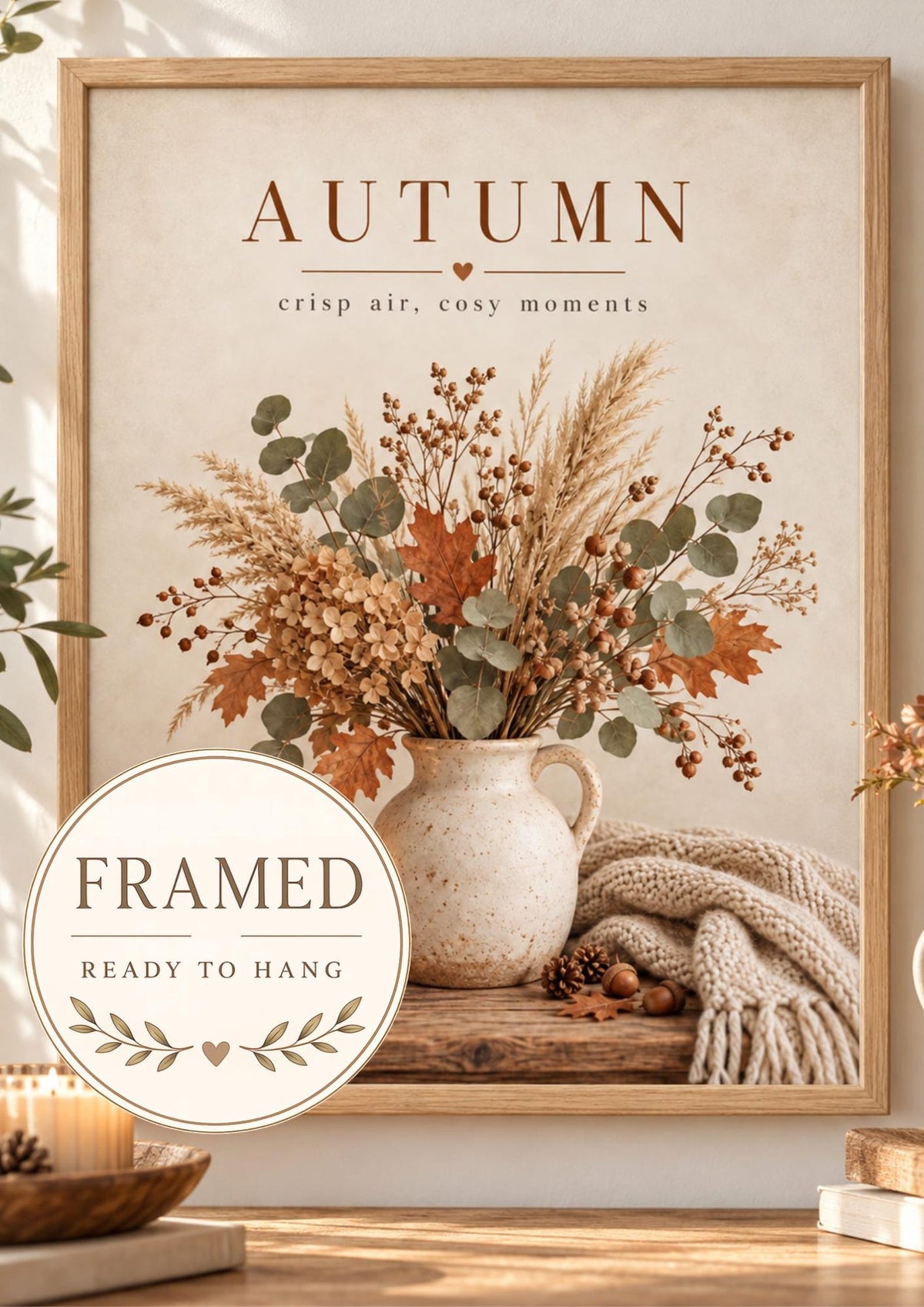Autumn crisp air cosy moments artwork with dried flowers, eucalyptus and grasses in a rustic vase, candle and knitted blanket; framed and ready to hang badge