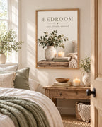 Bedroom rest dream unwind botanical artwork with eucalyptus, ceramic vase, candle, books and knitted blanket styled in a bedroom