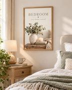 Bedroom rest dream unwind botanical artwork with eucalyptus, ceramic vase, candle, books and knitted blanket styled in a bedroom wall