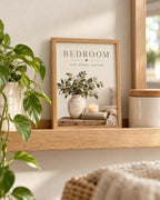 Bedroom rest dream unwind botanical artwork with eucalyptus, ceramic vase, candle, books and knitted blanket styled in a shelf