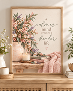 A calmer mind creates a kinder life quote with pink and ivory flowers, sage foliage, ceramic vase, candle, books and blush knitted throw; print only, frame not included