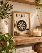 Vintage dartboard with Darts and aim, throw, repeat wording, rustic wood and greenery styled in a shelf display