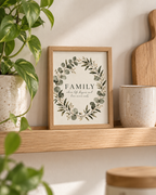 Family where life begins and love never ends quote surrounded by a sage green eucalyptus and white flower wreath styled in a shelf display