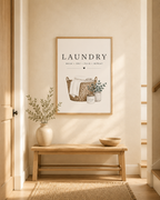 Laundry basket with folded linens, foliage and wash dry fold repeat lettering styled in a hallway