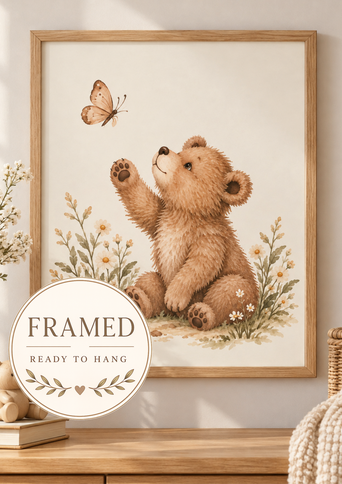 Watercolour teddy bear raising a paw towards a butterfly among daisies and soft foliage; framed and ready to hang badge