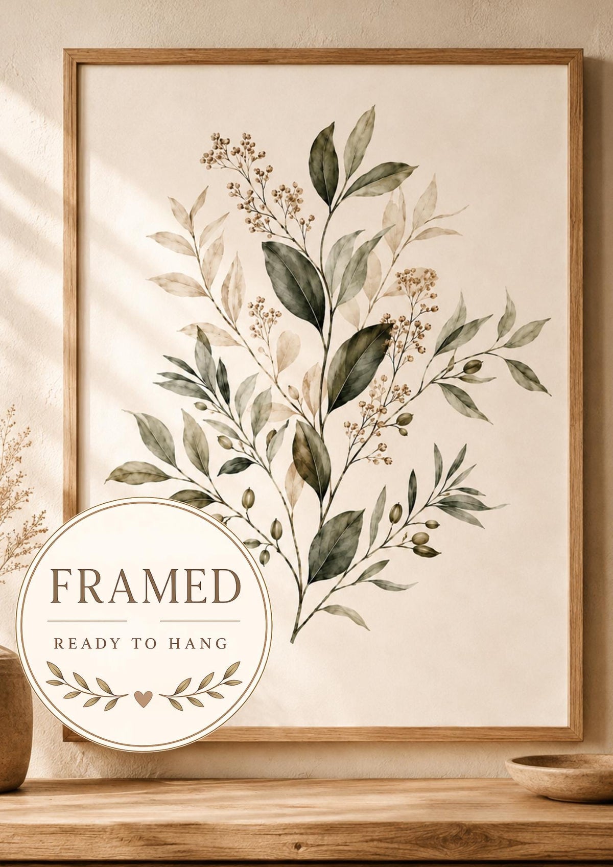 Neutral botanical leaves and delicate stems with beige berries on a warm cream background; framed and ready to hang badge