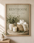 Restroom artwork with eucalyptus, woven basket, towel and candle; frame shown for styling only.